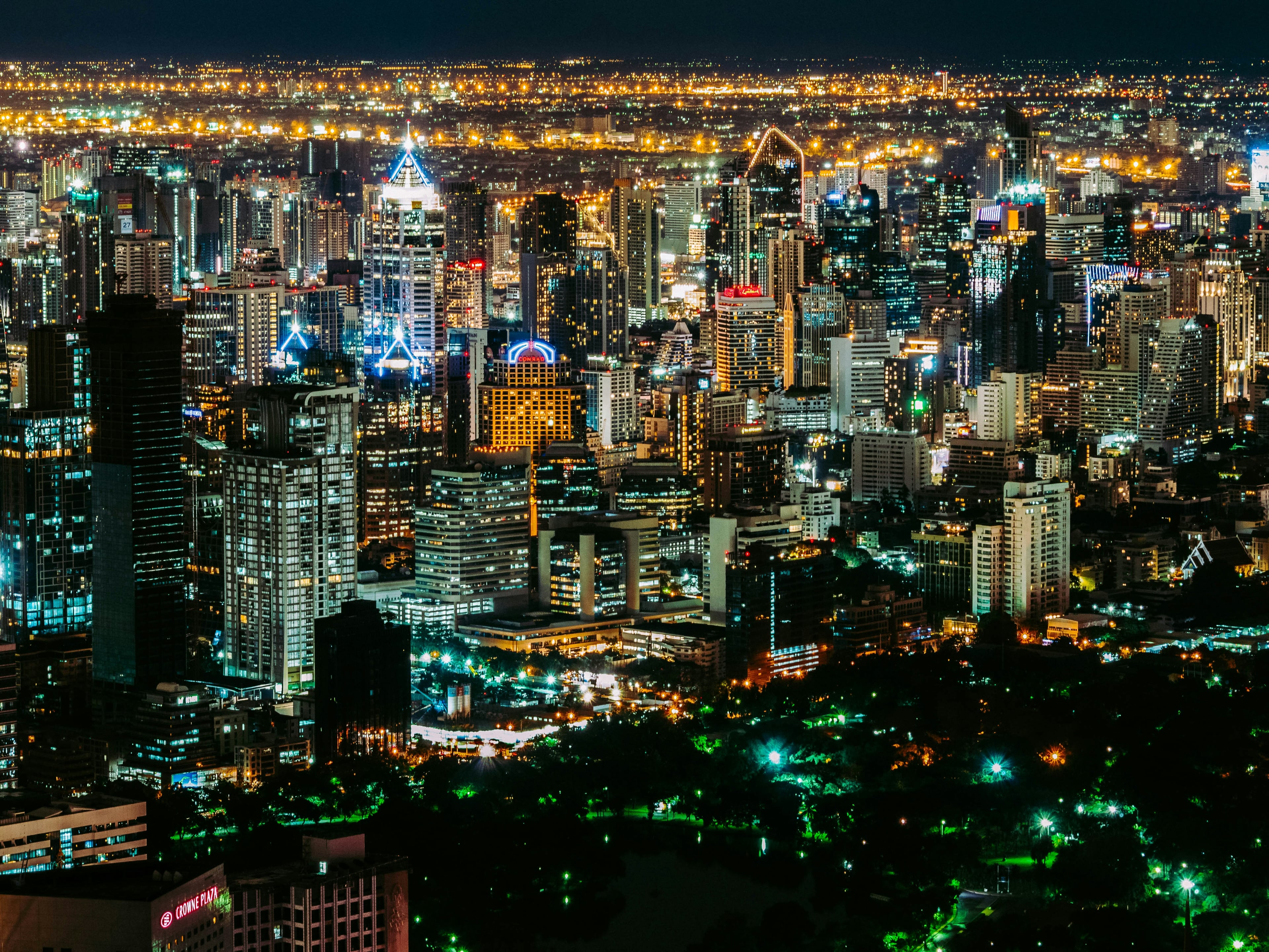 Bangkok's illuminated business skyline at night, with office towers and city lights.