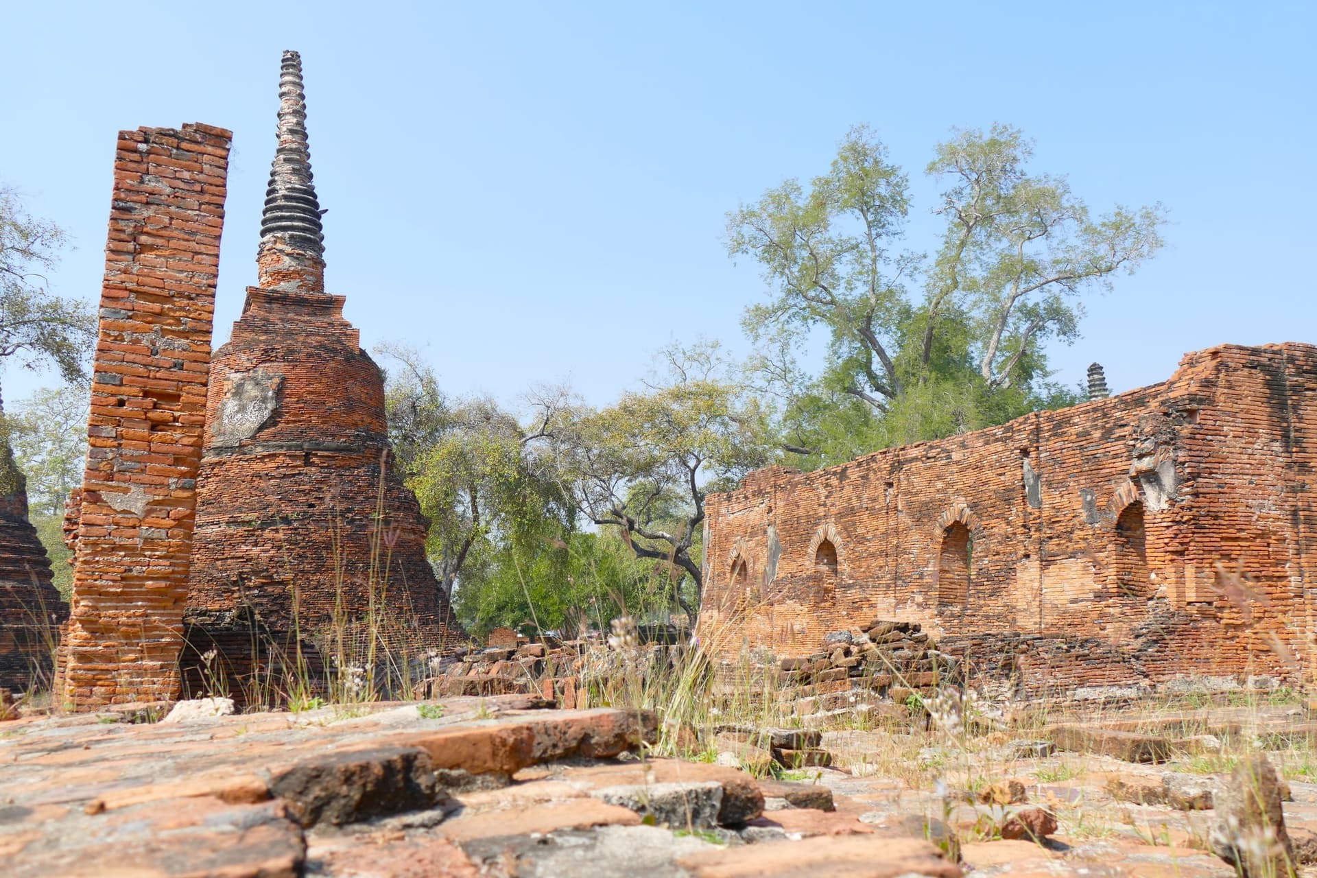 Brick chedi and ruined walls among trees at Ayutthaya, one of the towns on the overland route north from Bangkok.