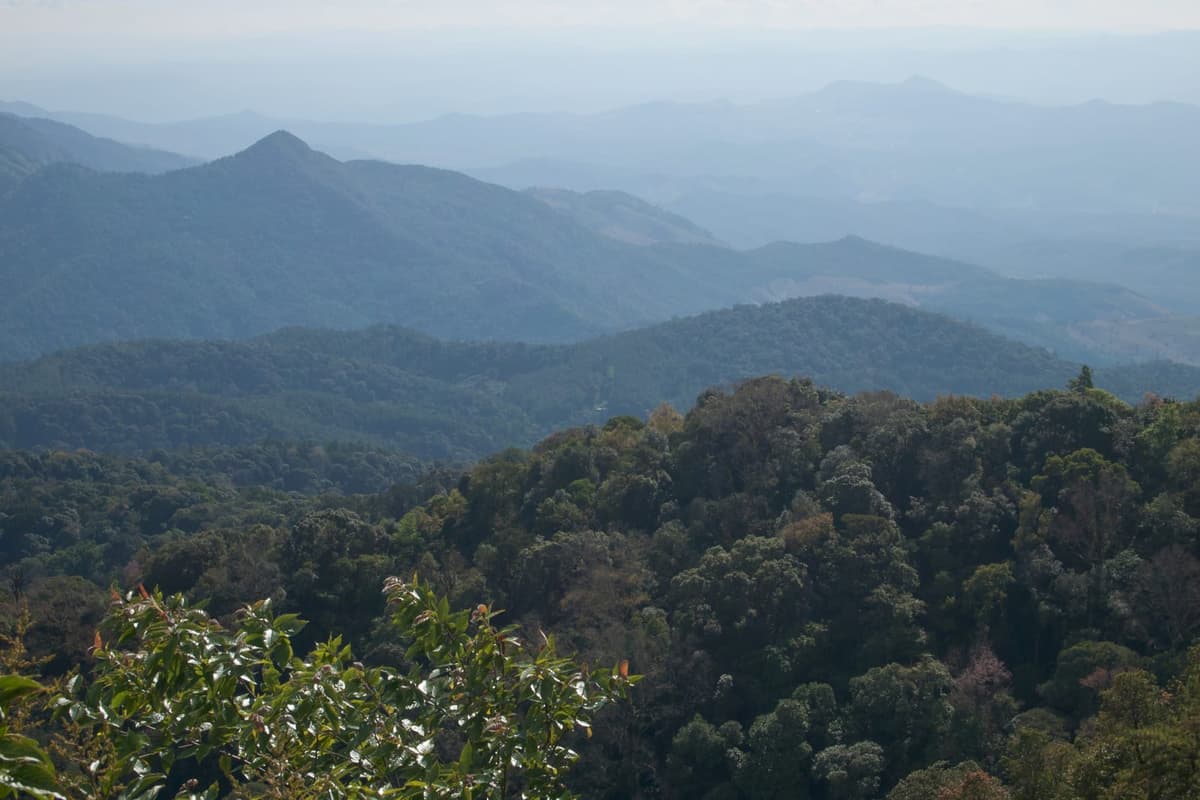 The forested hills of Doi Inthanon in northern Thailand, clear in the cool season and hazy during the spring burning weeks.