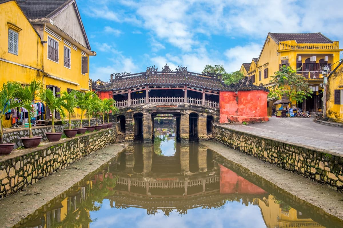 El Puente Cubierto Japonés reflejado en su canal, el monumento más fotografiado de la ciudad vieja de Hoi An iluminada por faroles.