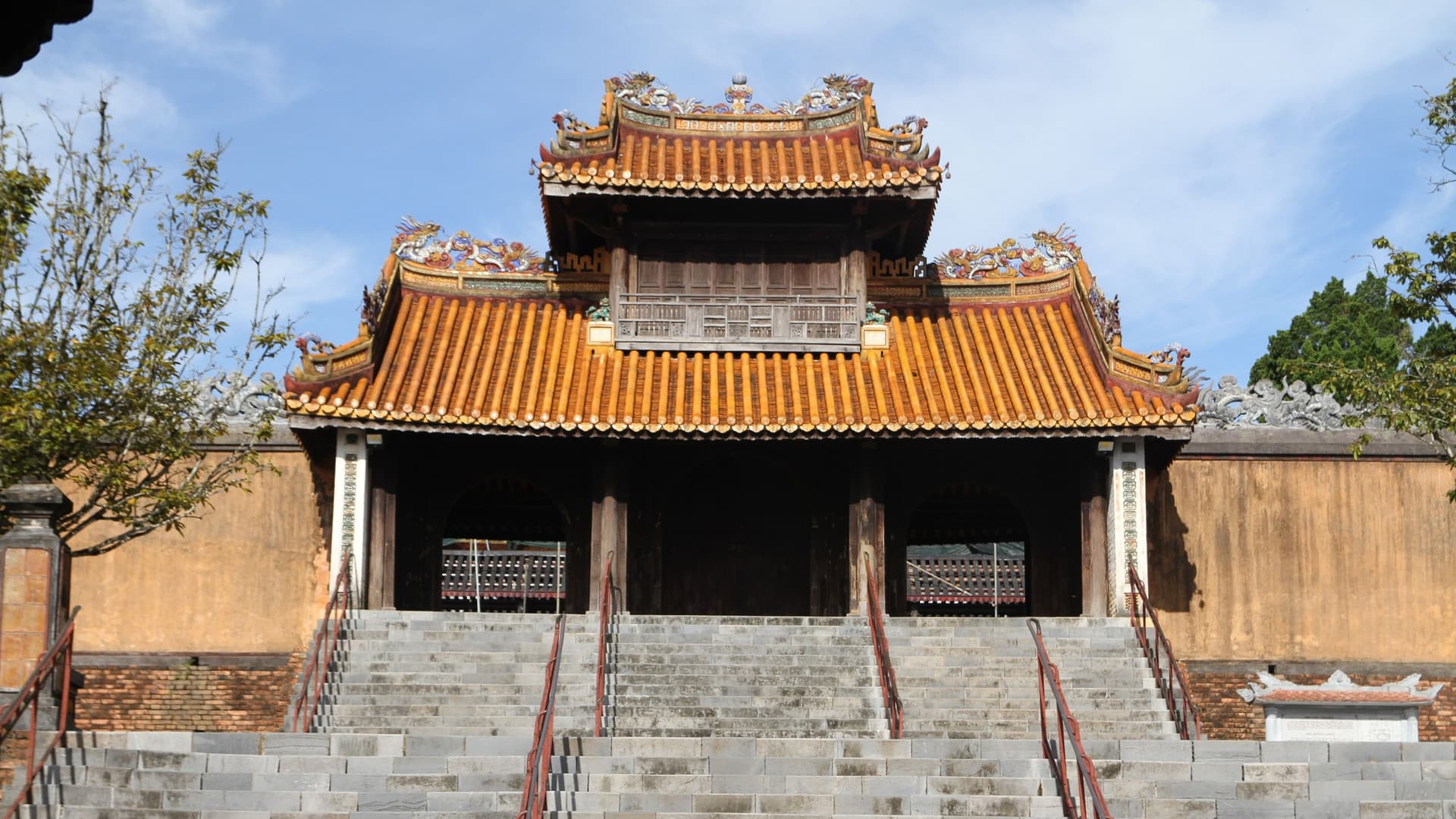A gate in the imperial complex at Hue under a clear sky, the anchor of the central leg.