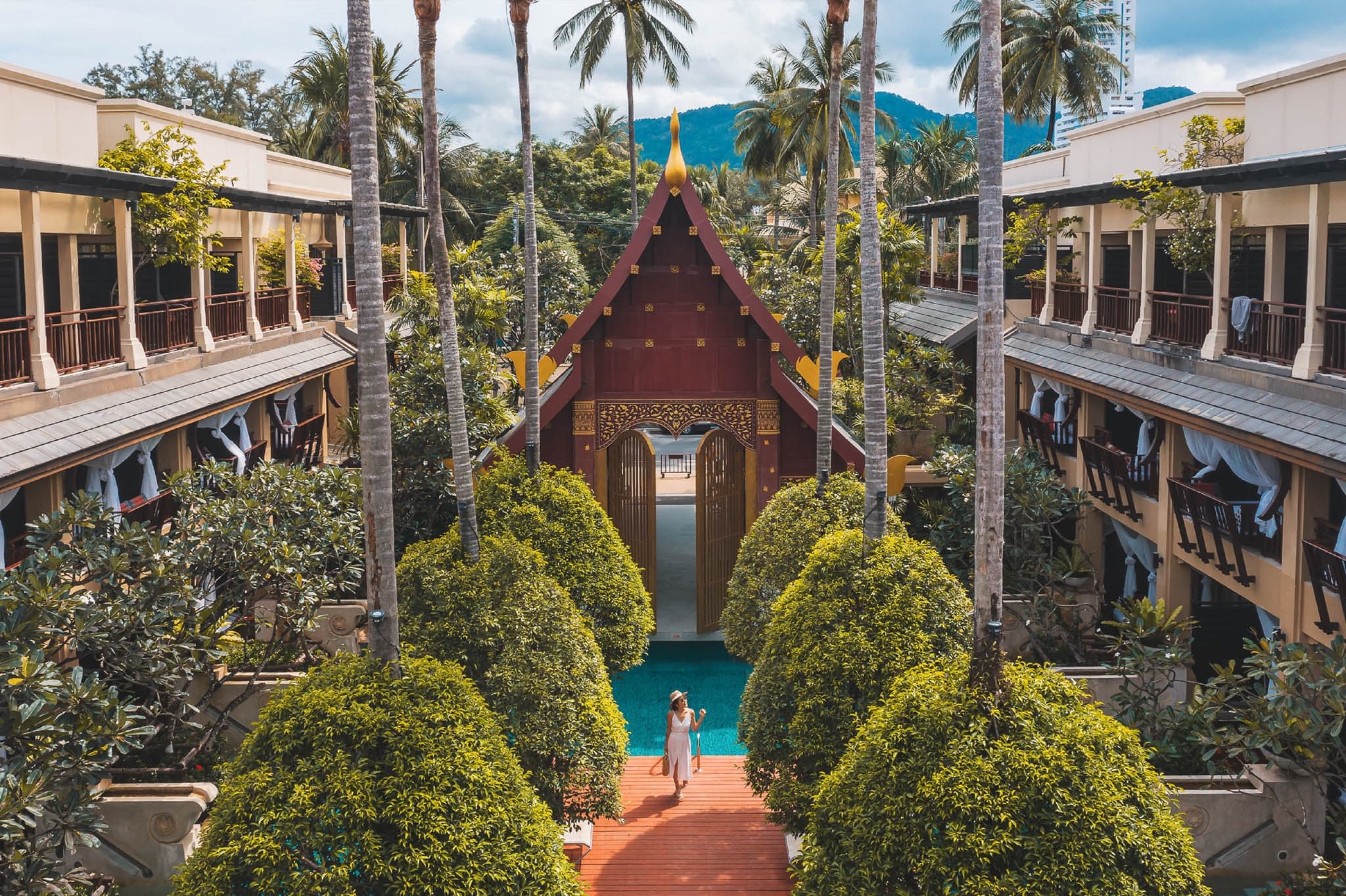 An aerial view of a Lanna-style boutique resort courtyard with a pool and palm trees, Patong, Phuket, Thailand