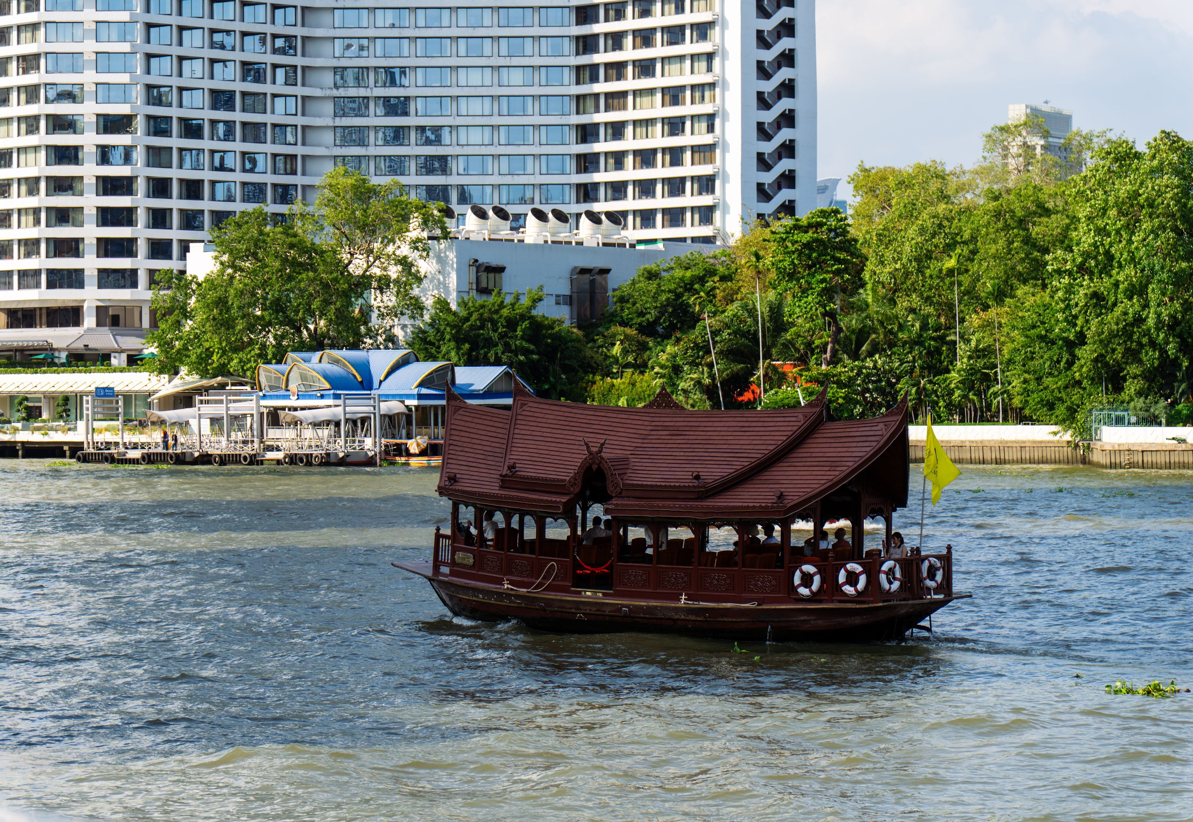 Perahu kayu tradisional dengan atap berukir khas Thailand di Sungai Chao Phraya, Bangkok