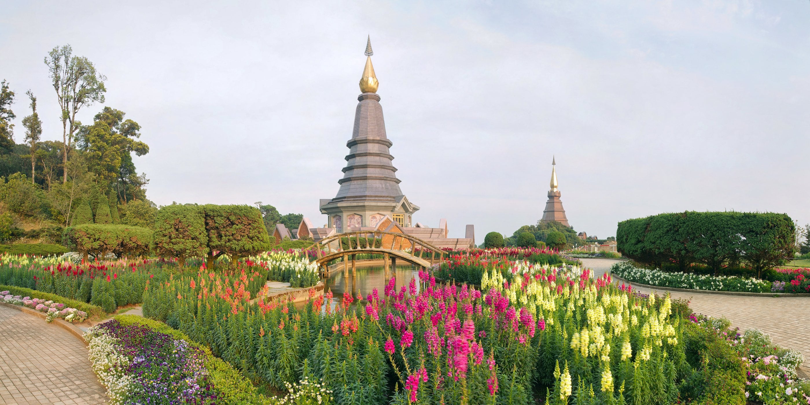 The twin royal chedis crowning Doi Inthanon, Thailand's highest peak, above the far northern mountains at golden hour.