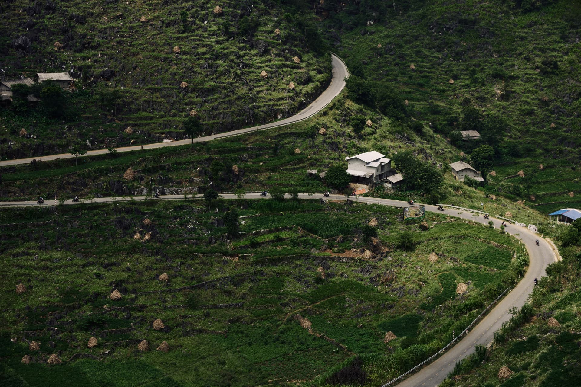 The loop road switchbacking through terraced karst country above Ha Giang, where the drive is the destination.