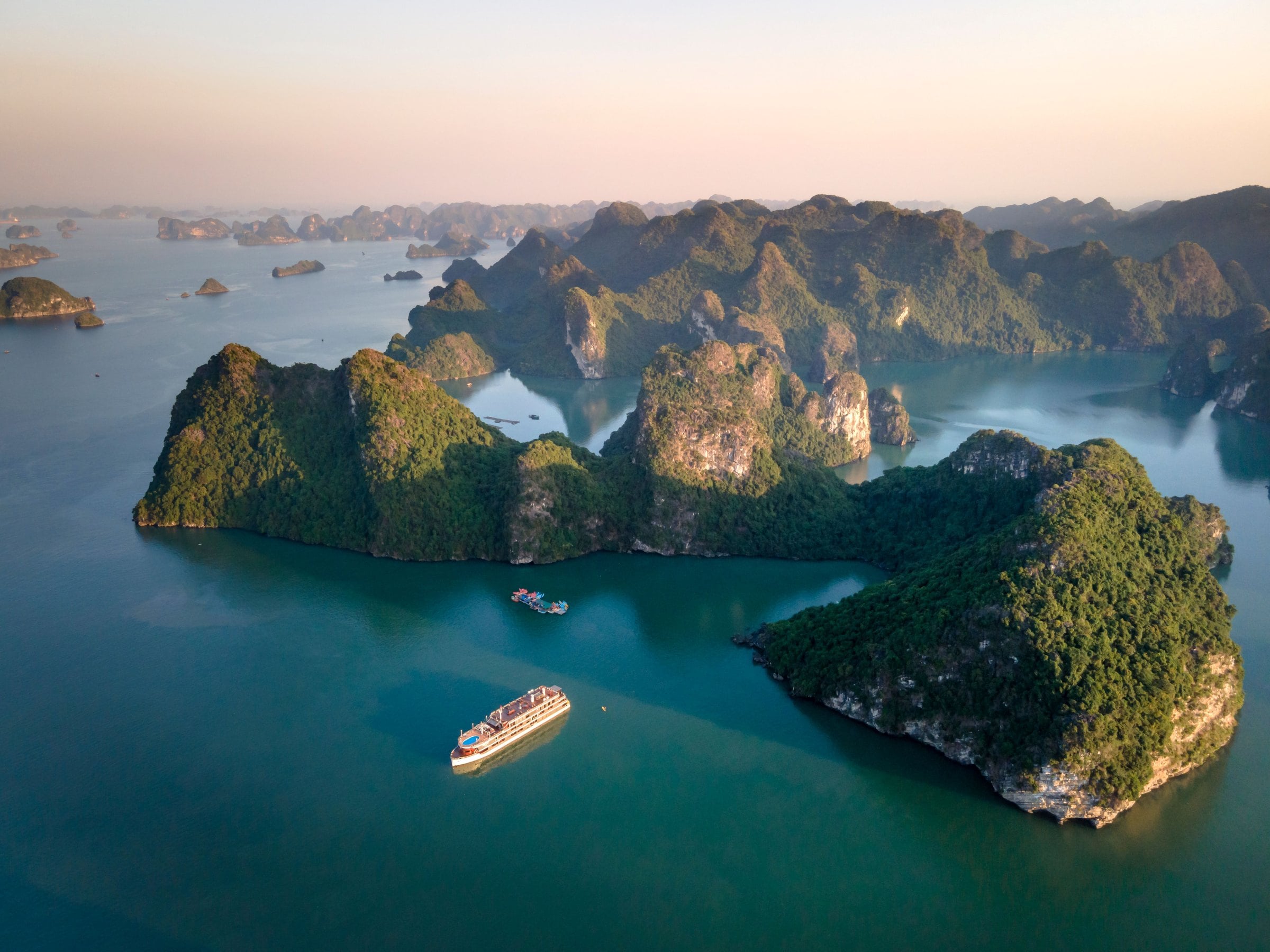 سفينة سياحية بين جزر من الحجر الجيري في خليج ها لونغ (Ha Long Bay)، من الجو