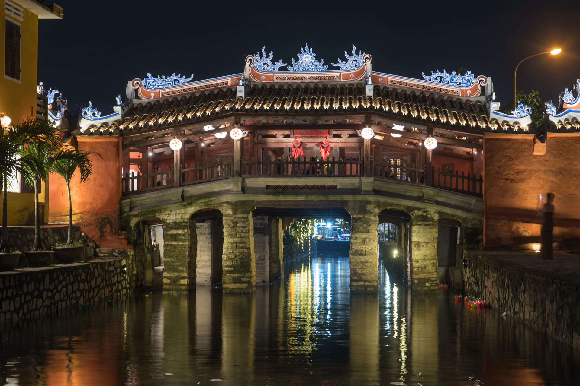 Japanese Covered Bridge dan bayangannya di kanal kota tua Hoi An.