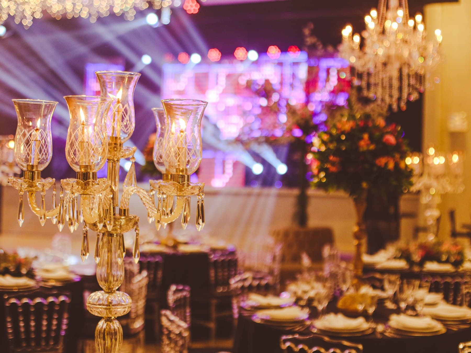 Crystal candelabra, glassware and florals on a table set for a gala dinner