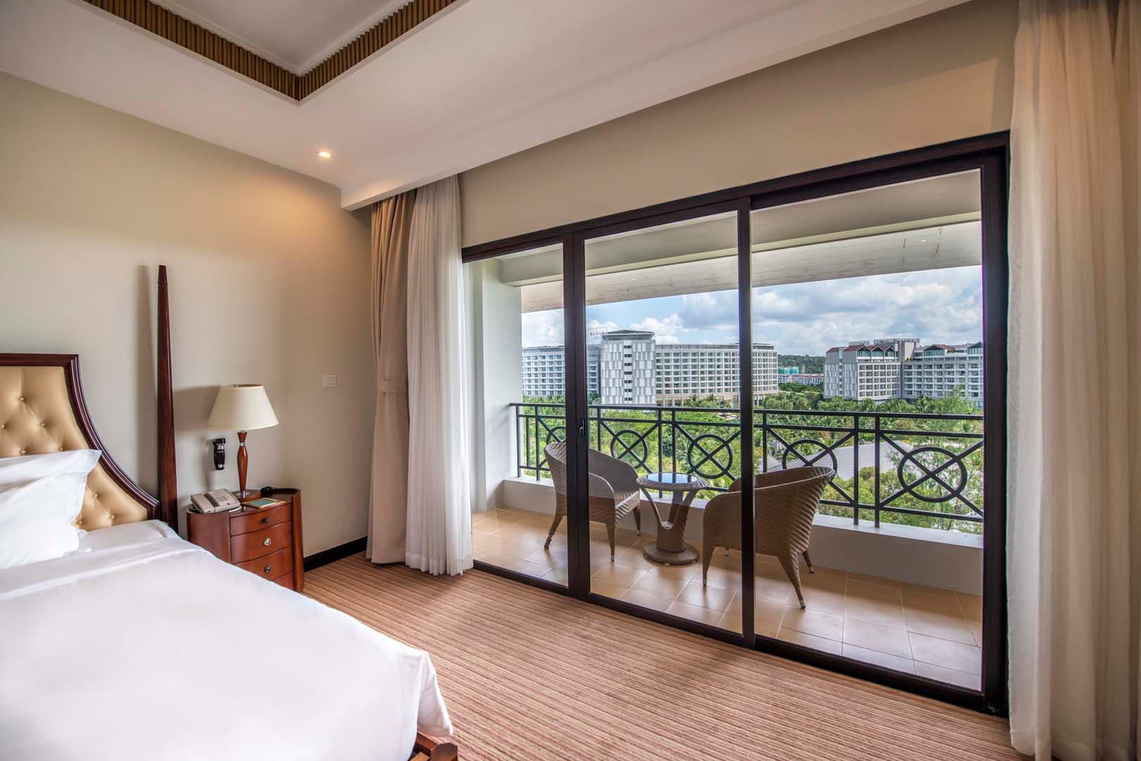 Luxury hotel room with balcony overlooking modern cityscape, corporate accommodation, Thailand