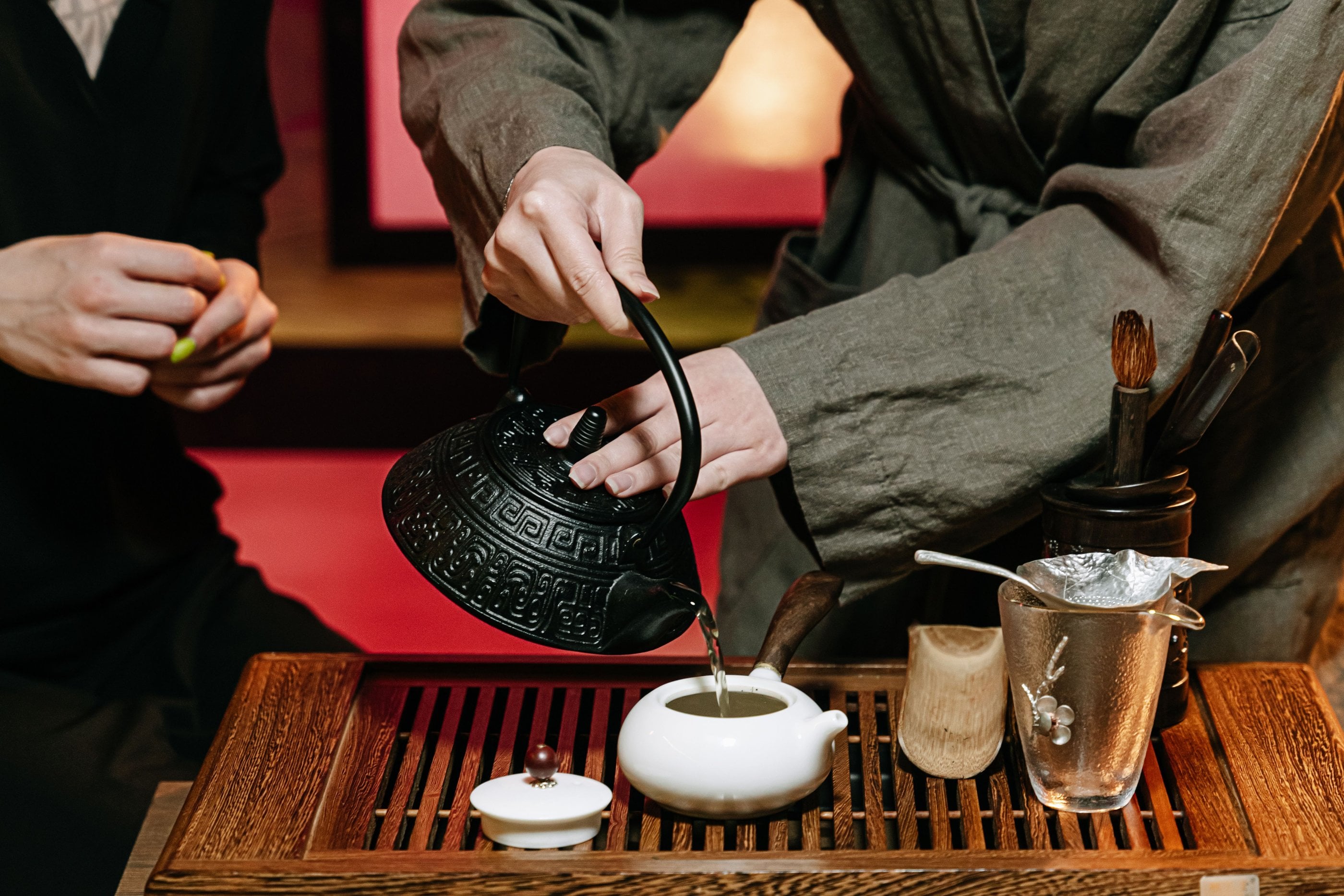 A Yunnanese-style tea tasting with a grower, cups and steam rising over a wooden tray.