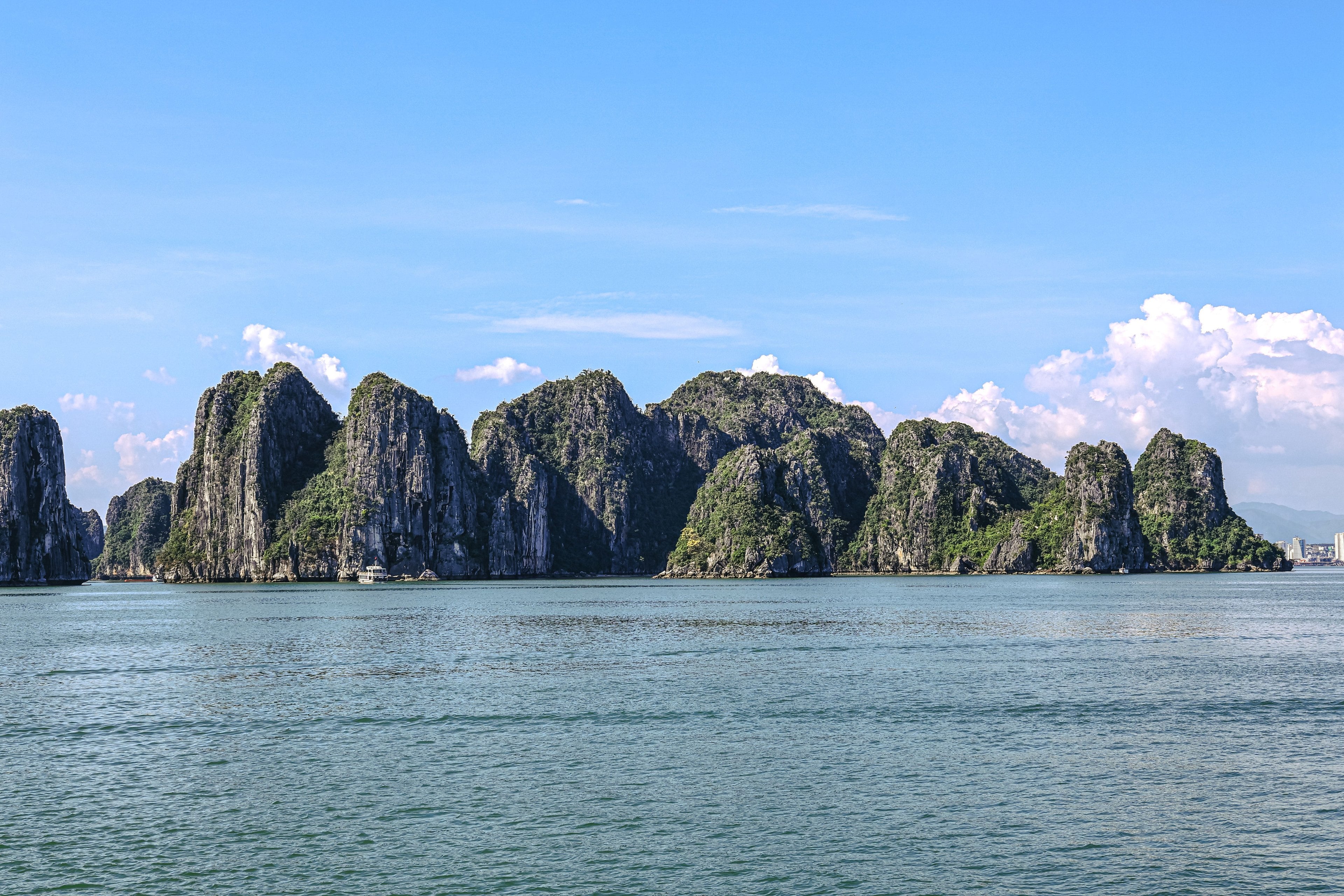 Islas de piedra caliza que se alzan sobre aguas tranquilas bajo un cielo azul, en el norte de Vietnam