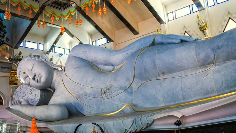 The reclining figure in the parinirvana posture, the Buddha's final passing, its length filling the marble sanctuary.