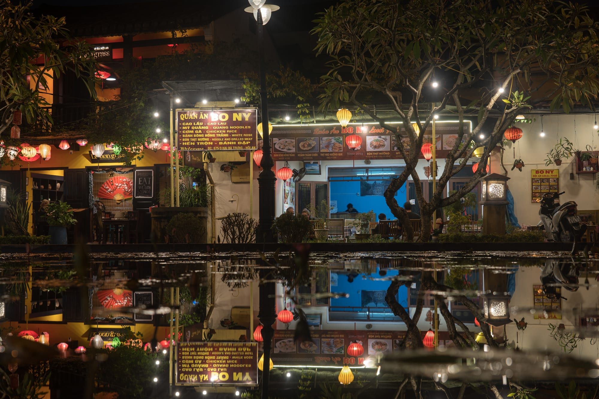 Hoi An's ancient town at dusk, lantern light over the tiled rooftops, a central anchor of the south-to-north route.